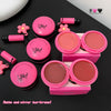Pink makeup products with a mirror and applicator on a black surface