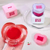 Heart-shaped red gel container with pink 'Gee Bear' logo on a white background