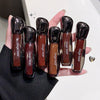 Hand holding six Gege bear lip glosses with a blurred background