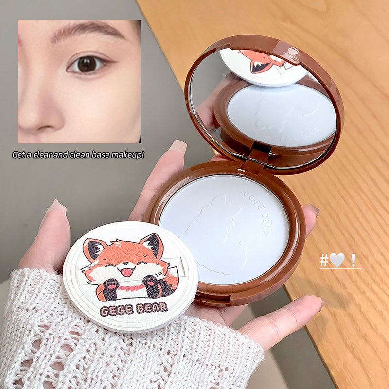Compact powder with cartoon fox design held by a hand on a wooden surface