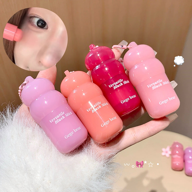Hand holding four pink lip balm tubes with 'Versatile Blush Stick' branding.