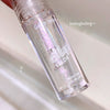 Lip oil bottle with glittery texture on a light background