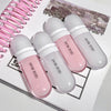 Four GEGE BEAR lip glosses in pink and white on a magazine background