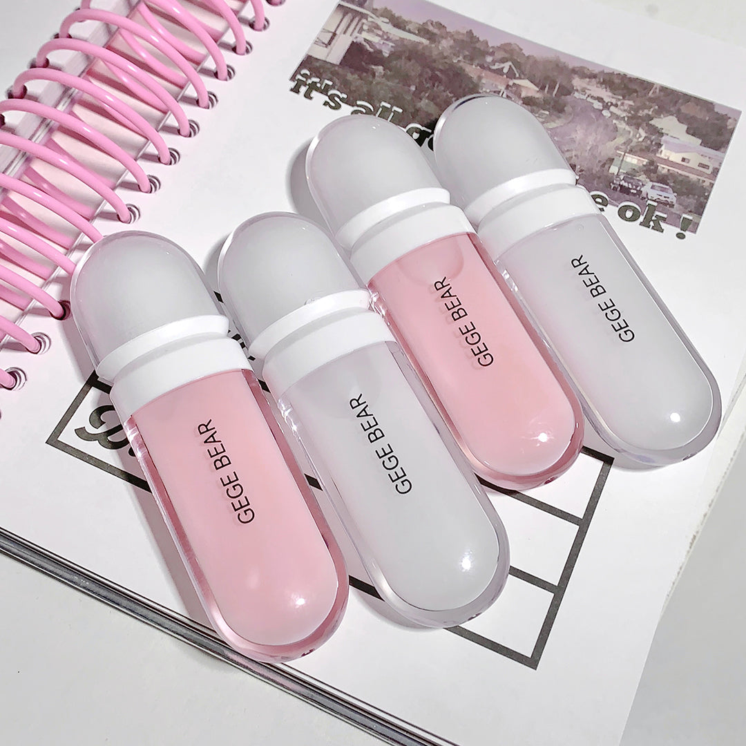 Four GEGE BEAR lip glosses in pink and white on a magazine background