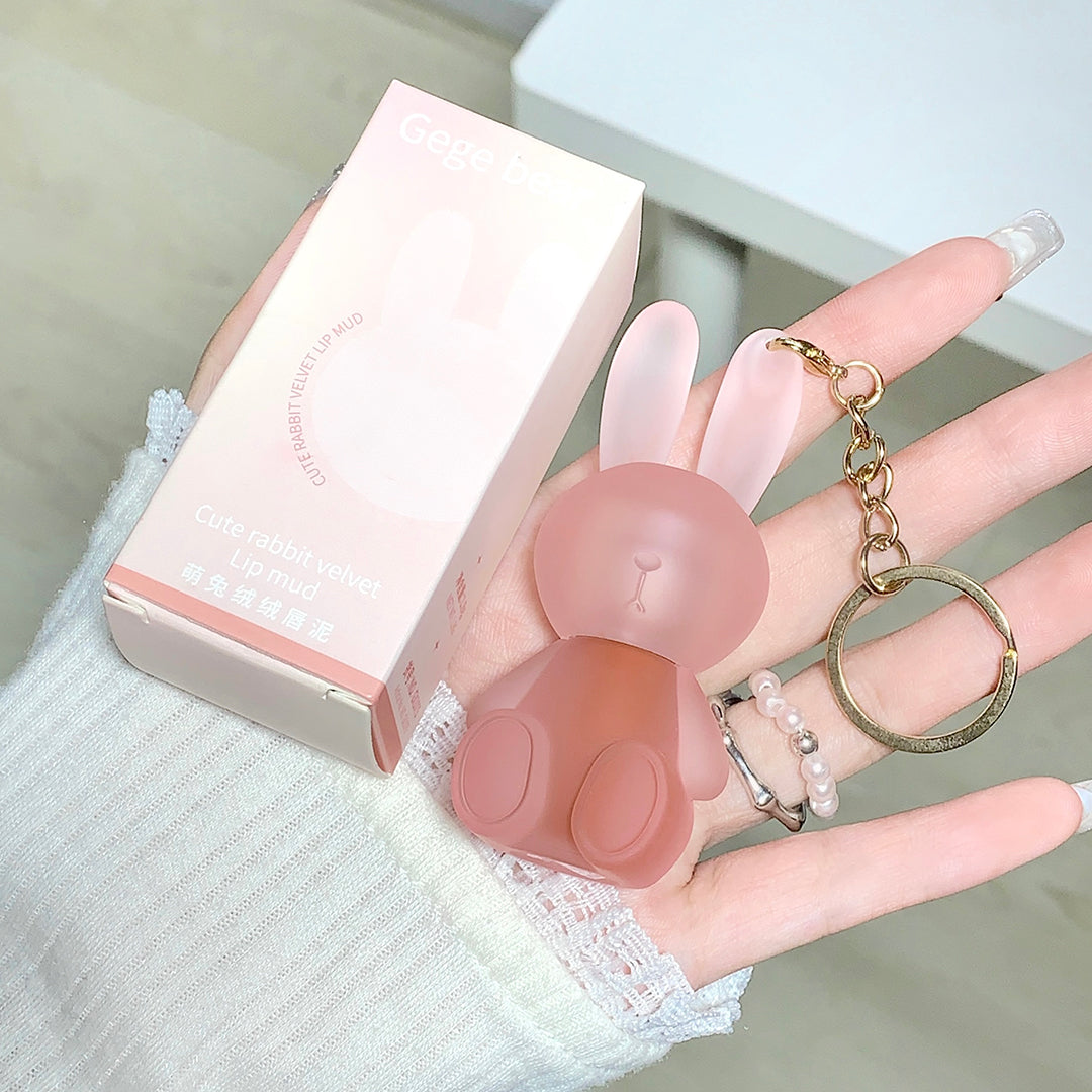 Pink rabbit-shaped keychain held by a hand with a blurred background