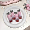 Pink lip gloss with bear-shaped caps on a white plate, branded 'Gege Bear'.