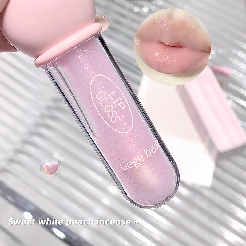 Pink lip gloss with 'Gege bear' branding on a reflective surface.