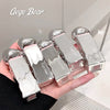 Hand holding multiple silver and pink 'Gege Bear' products against a neutral background