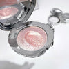 Compact mirror with pink glittery powder on a white background
