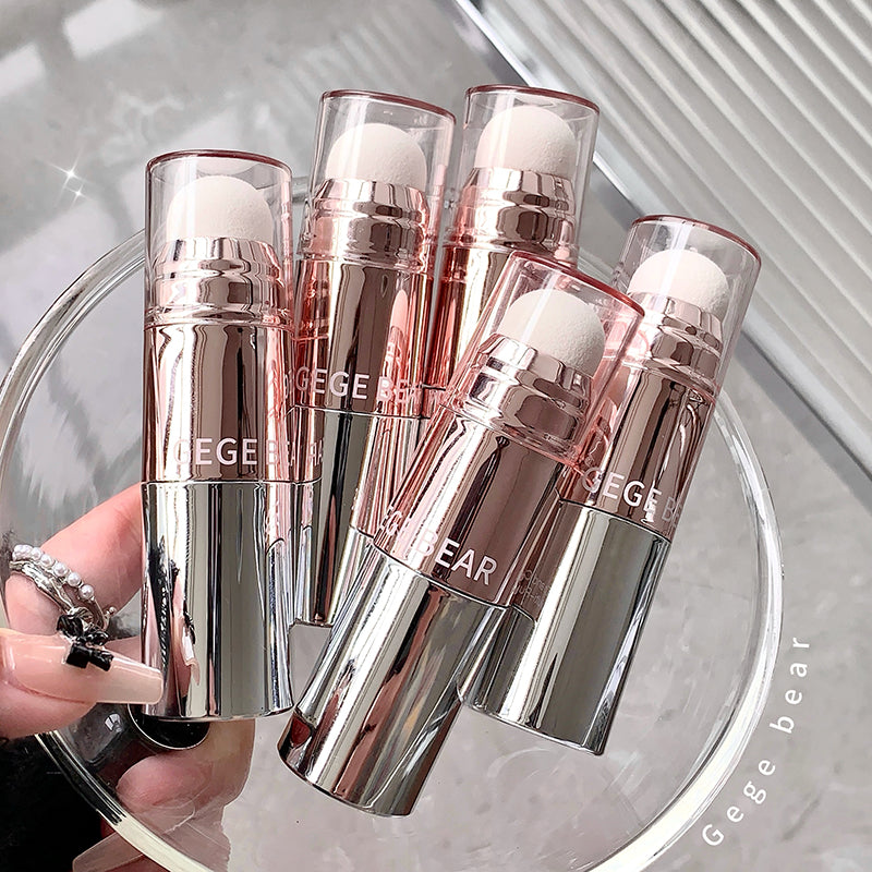 Five silver and rose gold lip glosses with 'Gebe Bear' branding held by a hand.