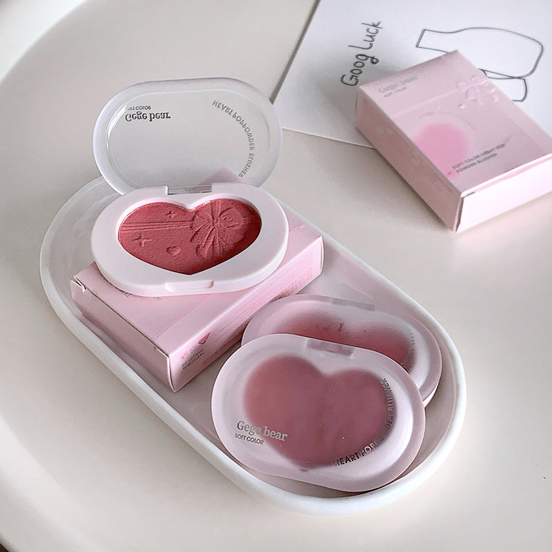 Heart-shaped blush compact with open lid on a white surface