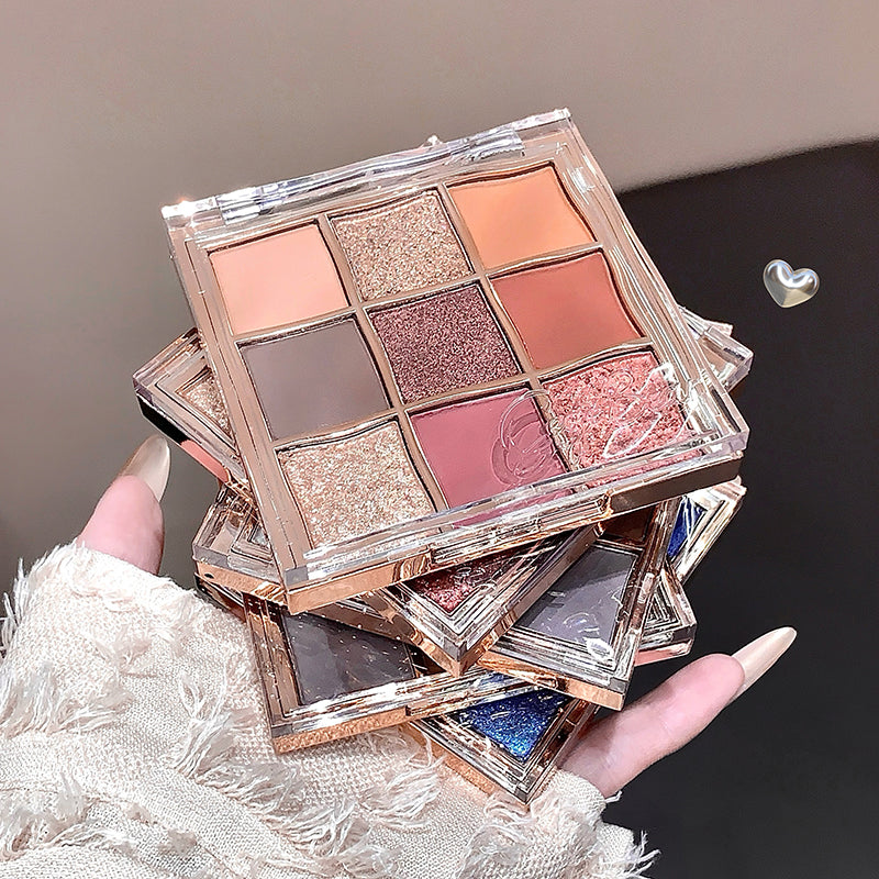 Makeup eyeshadow palette held by a hand with a neutral background