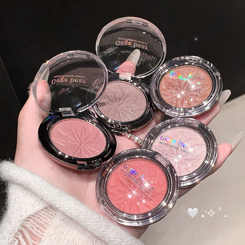 Hand holding multiple compact blushes with 'Gige Pige' branding.
