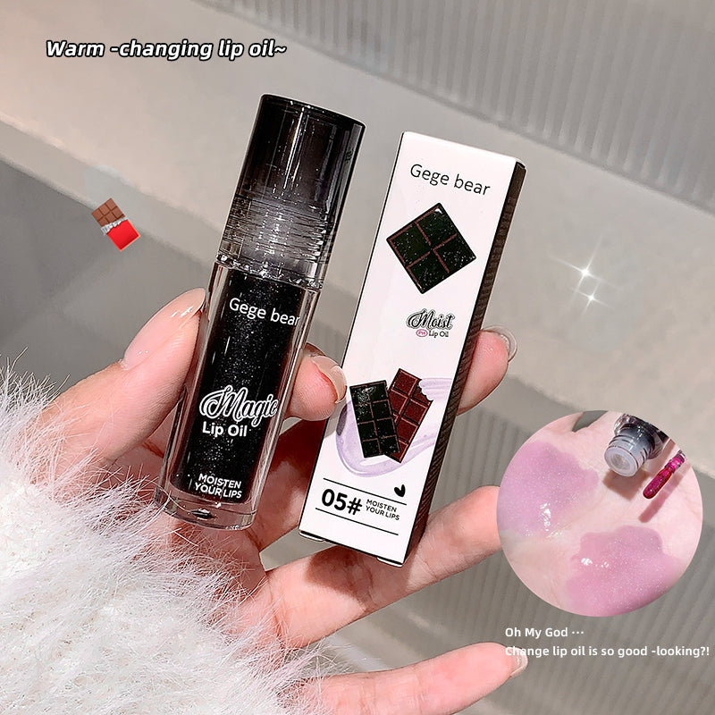 Lip oil with packaging held in a hand, showing brand 'Geege bear'.