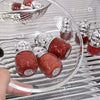 Red and silver bear-shaped candies in a clear glass bowl with 'Gee Bear' branding.