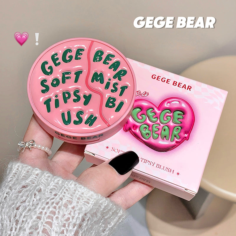 Pink 'GEGE BEAR' makeup product held by a hand with a matching box in the background.