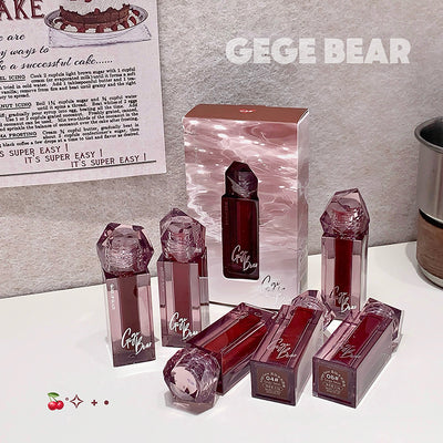 Collection of GEGE BEAR lip products on a white surface with a gray background