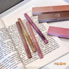 Set of lipsticks on an open book with a box in the background