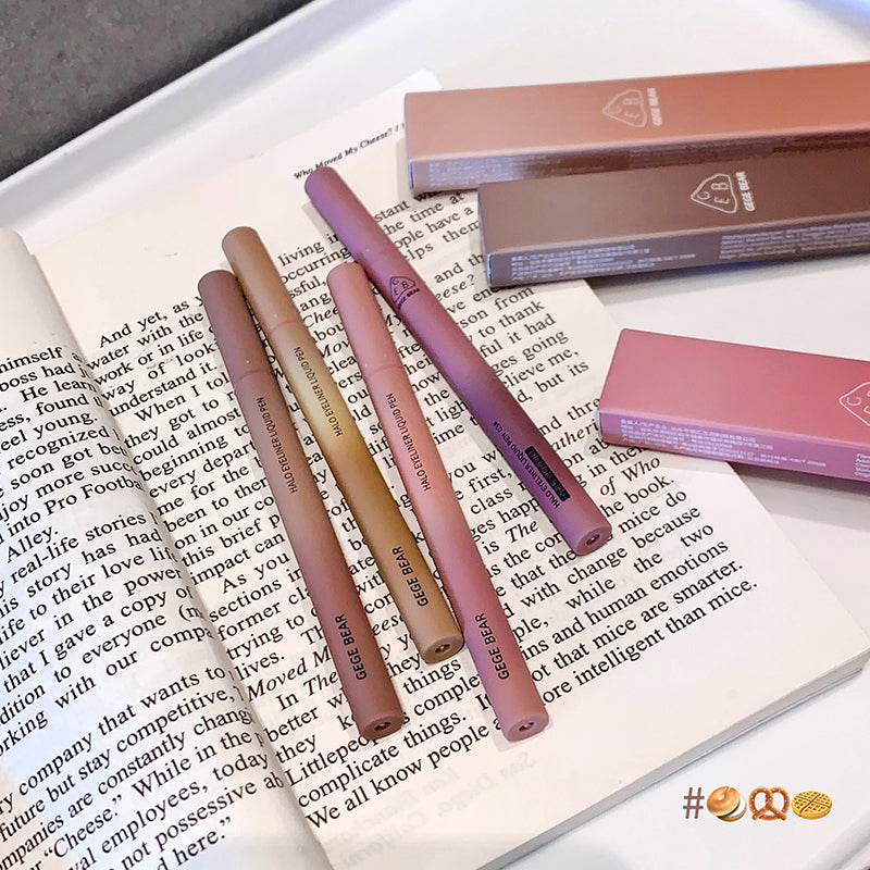 Set of lipsticks on an open book with a box in the background