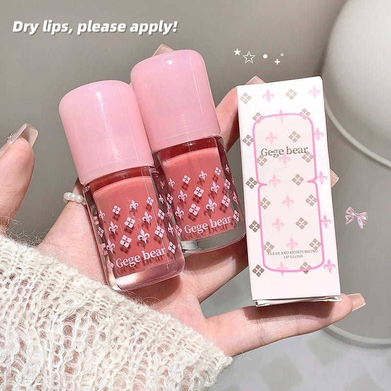 Two pink lip products with a Gege bear box held in a hand against a neutral background.
