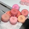 Collection of cosmetic jars with a brand logo on a white surface