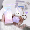 Cute bunny-shaped product with a keychain held by a hand, next to its packaging.
