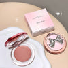 Makeup compact with pink blush and bow design, accompanied by a pink box labeled 'GEGE BEAR' on a beige surface.