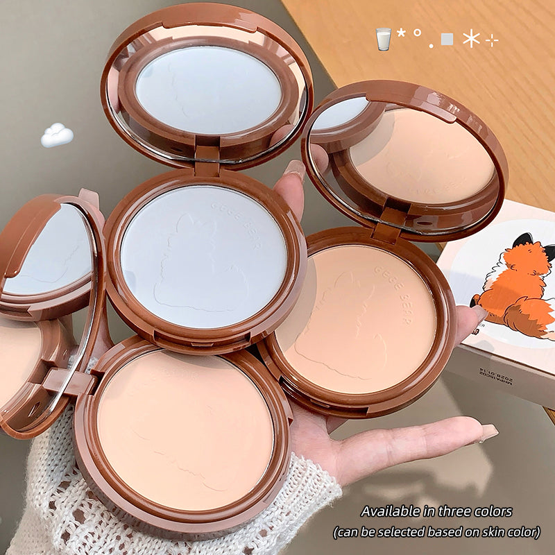 Open compact powder cases showing different shades held by a hand.