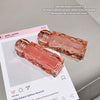 Two pink lip glosses with 'gege bear' branding on a light gray background.