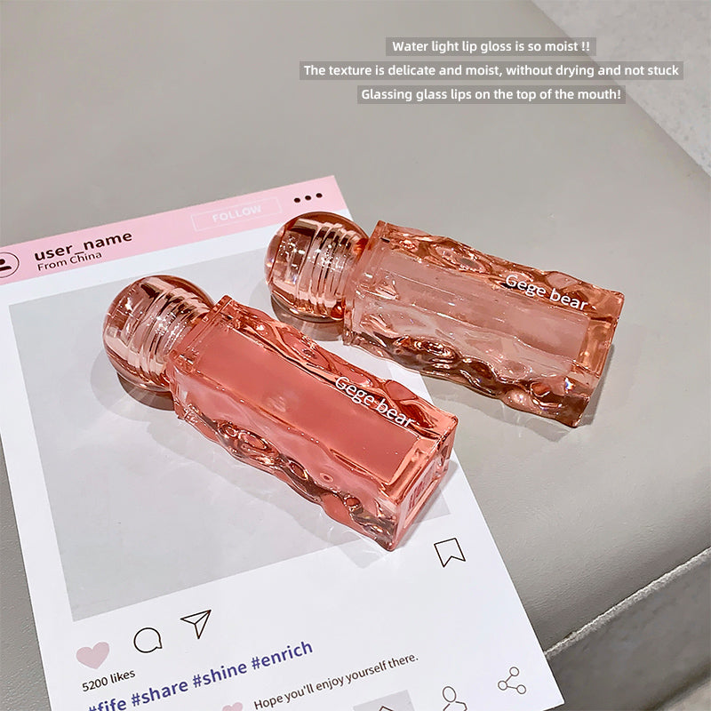 Two pink lip glosses with 'gege bear' branding on a light gray background.