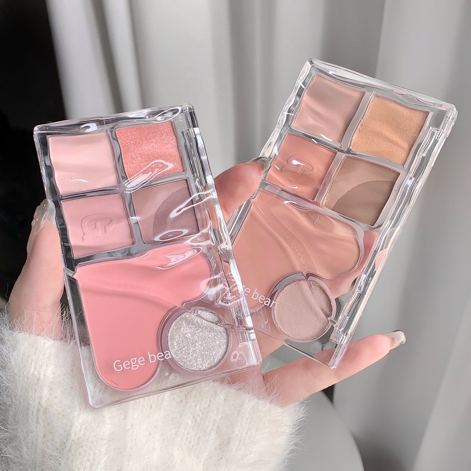 Makeup palette with blush and eyeshadow shades held by a person.
