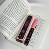 Two pink and black pens with a visible brand logo on an open book.
