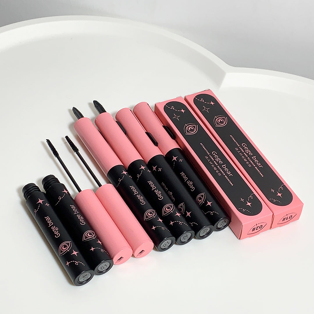 Set of pink and black mascara with packaging on a white surface
