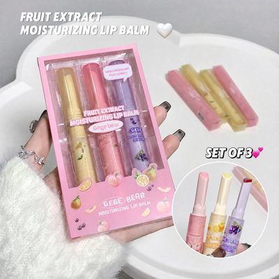 Set of three fruit extract moisturizing lip balms in a pink packaging with a hand holding the packaging.