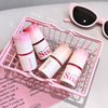 Four cosmetic bottles with 'Stic' branding on a pink wire basket, next to sunglasses.