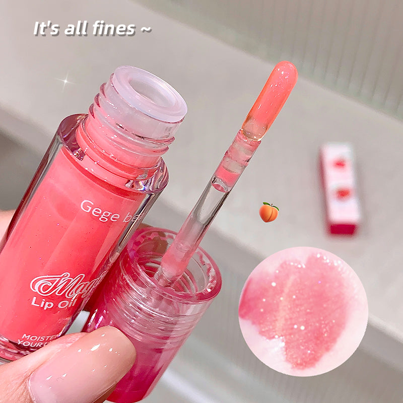 Pink lip gloss with applicator and close-up of product on a neutral background