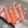 Hand holding five small transparent bottles with pink liquid and 'Geege bear' branding.