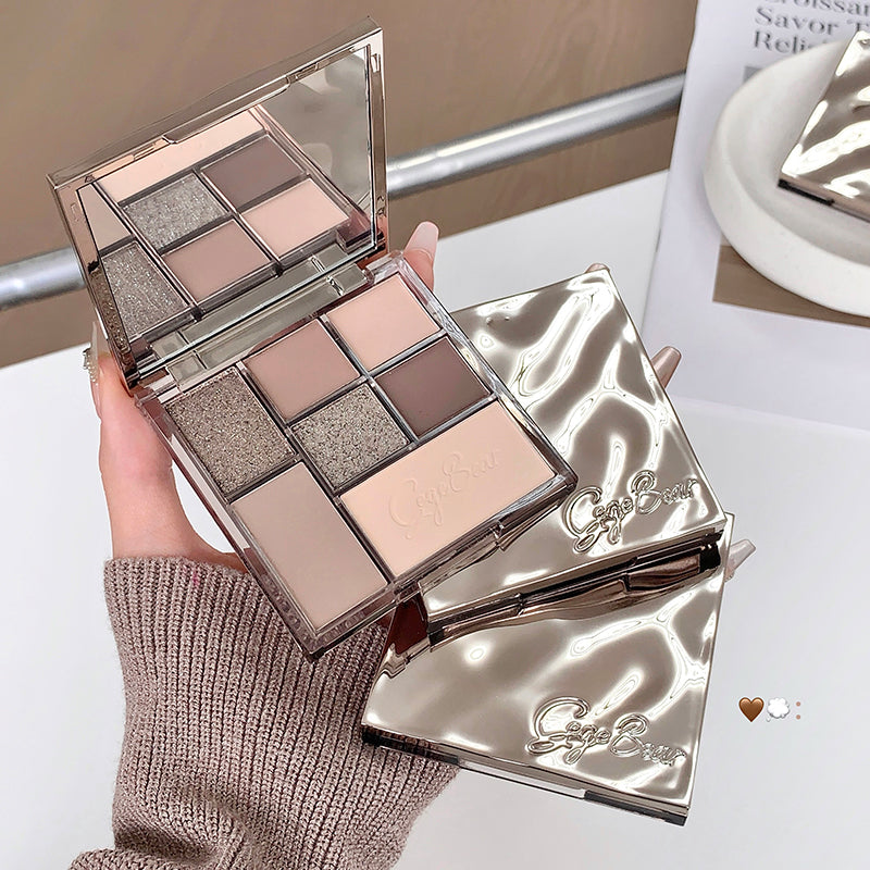 Makeup palette with a mirror held by a hand, on a neutral background