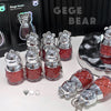 Collection of GEGE BEAR products including small bottles and keychains on a white surface.