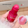 Pink blush stick with a small amount of blush on a finger, held by a hand.
