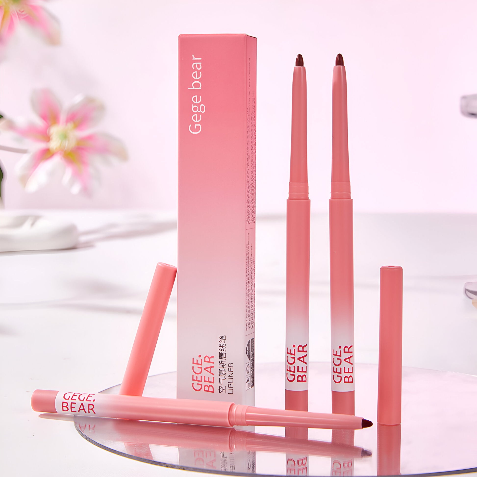 Pink lip liner with packaging on a white surface with floral background