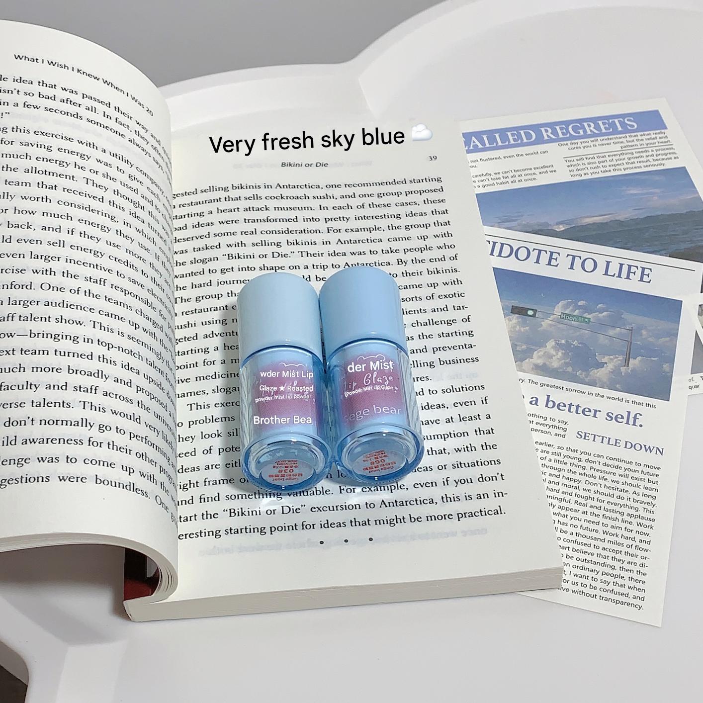 Two blue bottles labeled 'Brother Bear' on an open book with a newspaper on a gray background.