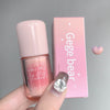 Pink lip gloss with 'Gege bear' branding held by a hand against a gray background