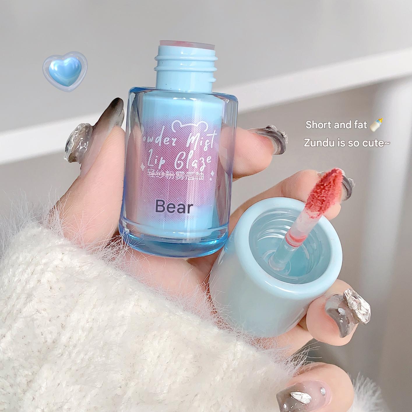 Lip gloss with a blue gradient and 'Gee bear' branding held by a person.