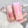 Pink lip gloss with packaging labeled 'Gege bear' held by a hand on a white background.
