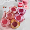 Collection of small lip balm jars with visible brand name on a light background
