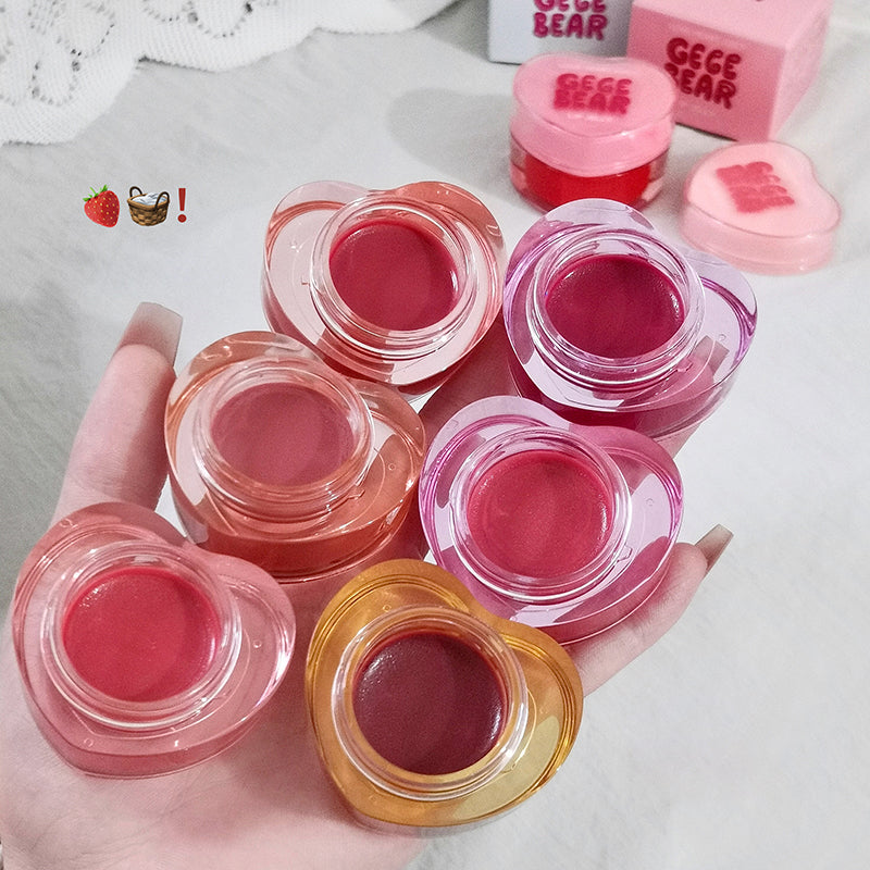 Collection of small lip balm jars with visible brand name on a light background