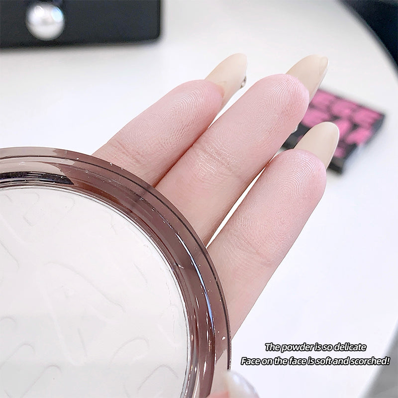 Hand with beige nail polish holding a makeup compact, with text describing the powder's texture.