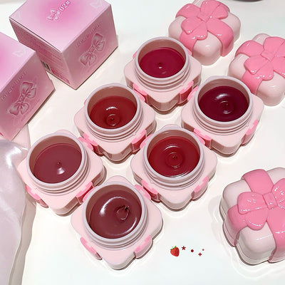 Pink lip balm containers with a strawberry design on a white background