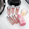 Pink and silver lip glosses with a pink box on a white surface.